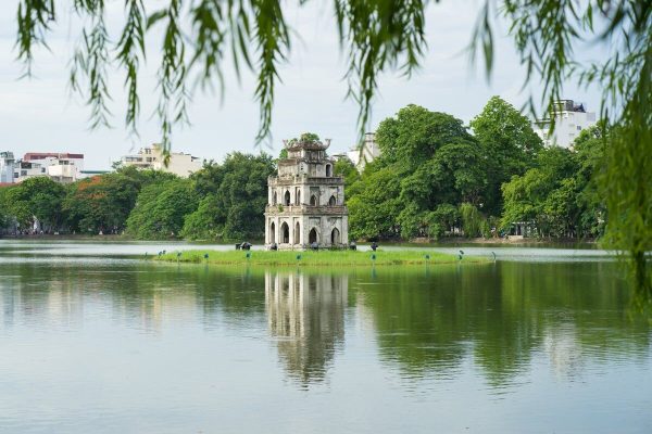 Scenic Hoan Kiem Lake in the heart of Hanoi, featuring the iconic Turtle Tower and The Huc Bridge leading to Ngoc Son Temple