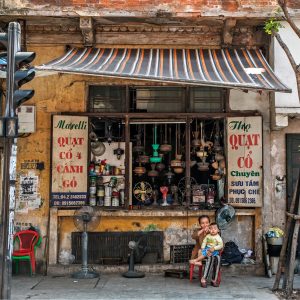 A bustling street scene in Hanoi’s Old Quarter, showcasing traditional shophouses, street vendors, and the vibrant culture of Vietnam’s capital